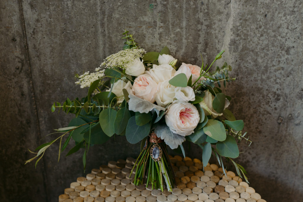 green and light pink bouquet on concrete wall