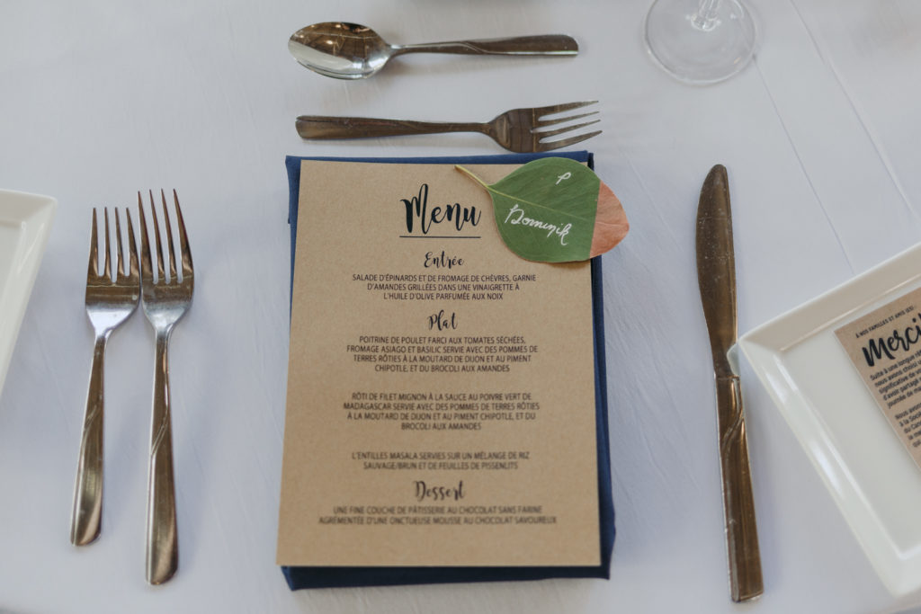 navy and white place setting with green leaf name tag