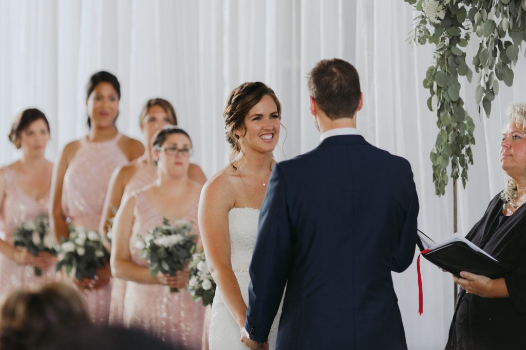 bride smiling at the groom during the ceremony