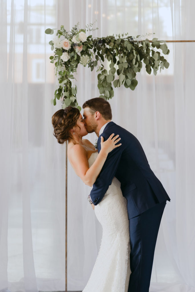 first kiss under floral arch