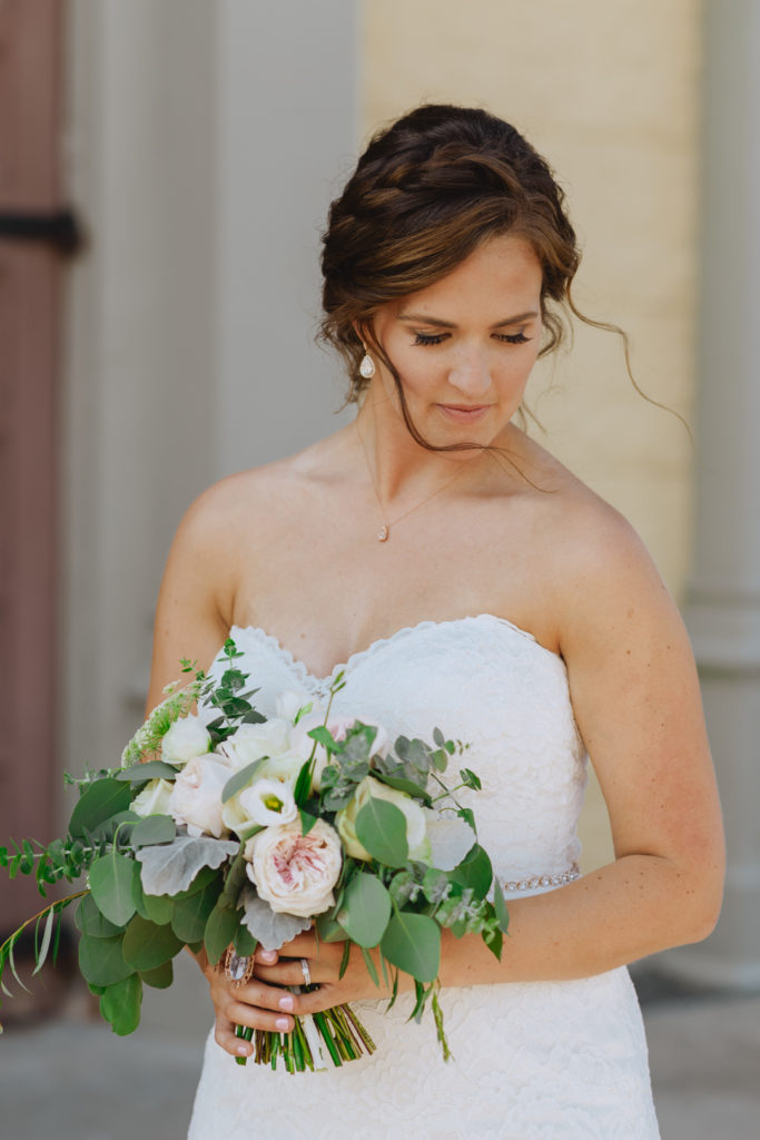 bride holding her bouquet with her hair blowing in the wind
