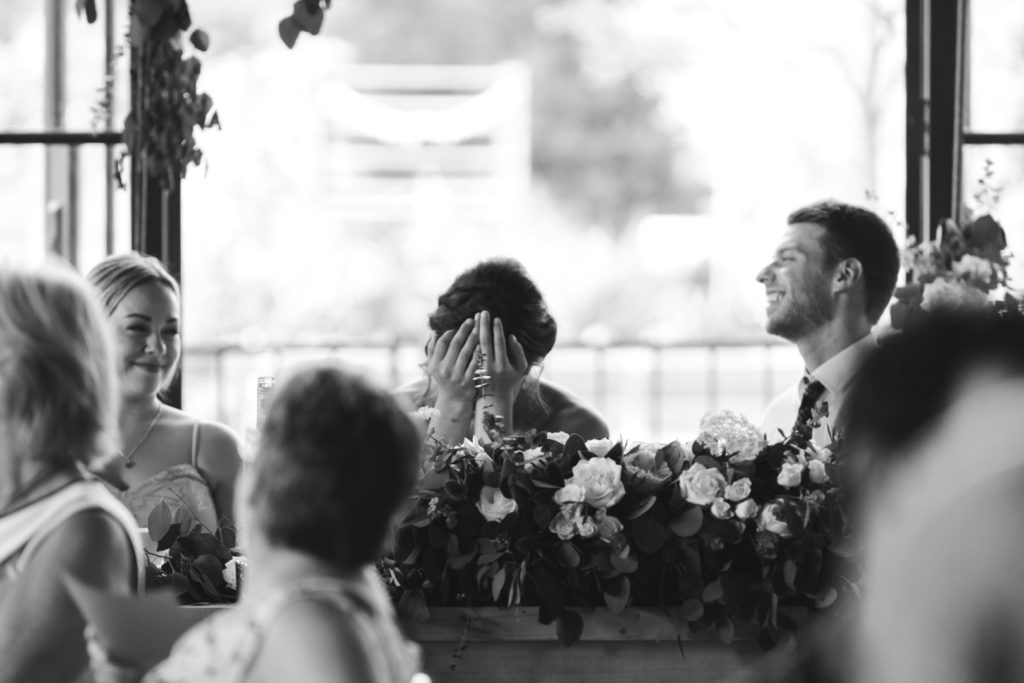 bride covering her face with her hands laughing
