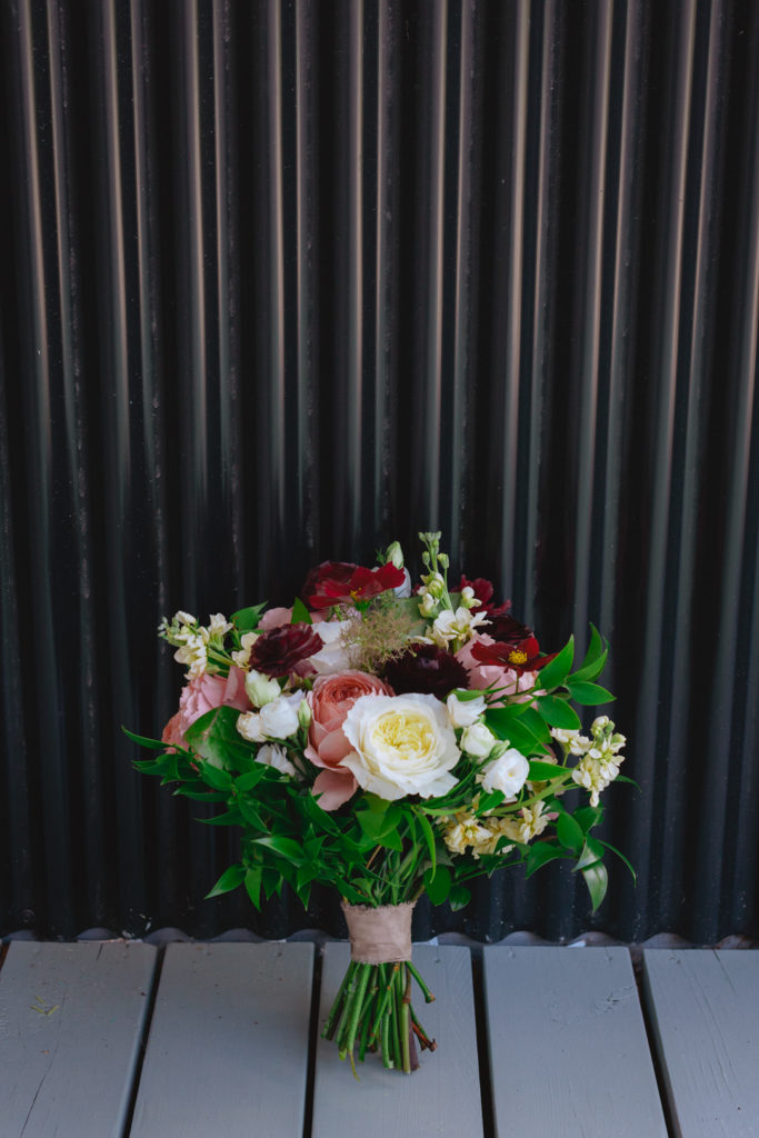 Wedding bouquet from Pollen Nation against black metal wall