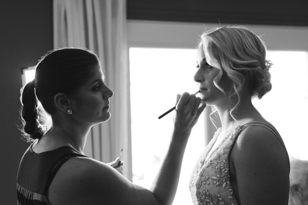bride getting the finishing touches on her lipstick by Shannon of One Fine Beauty