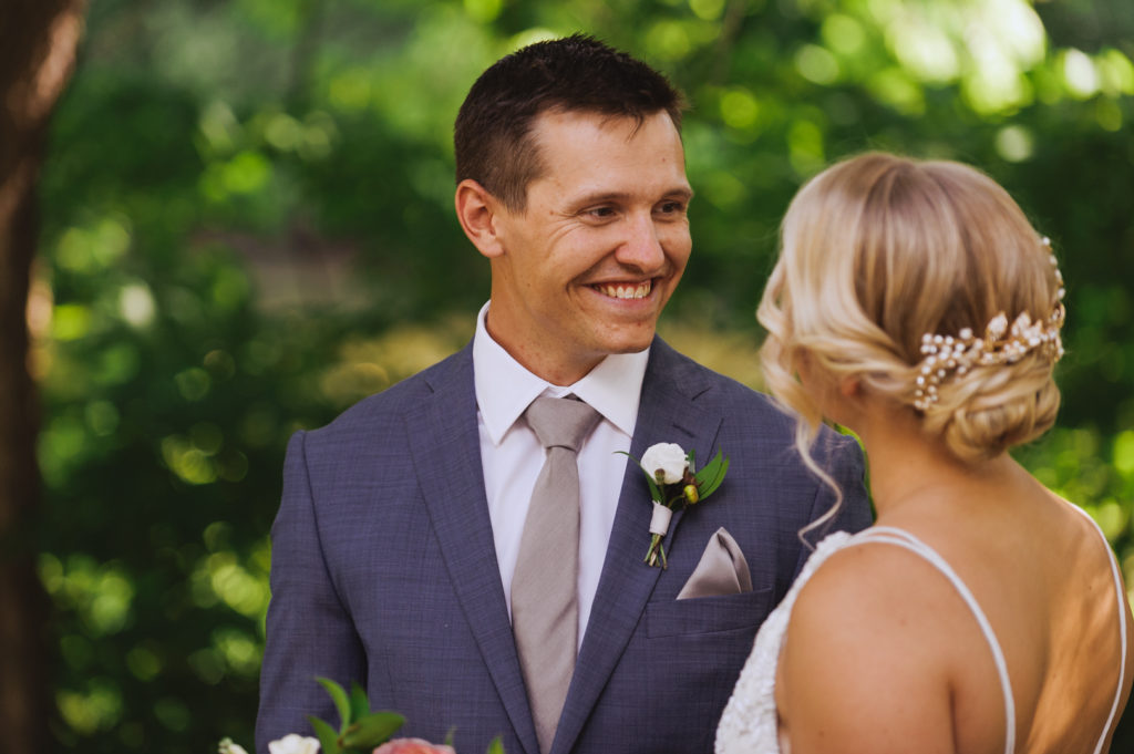 groom smiling at his bride during first look