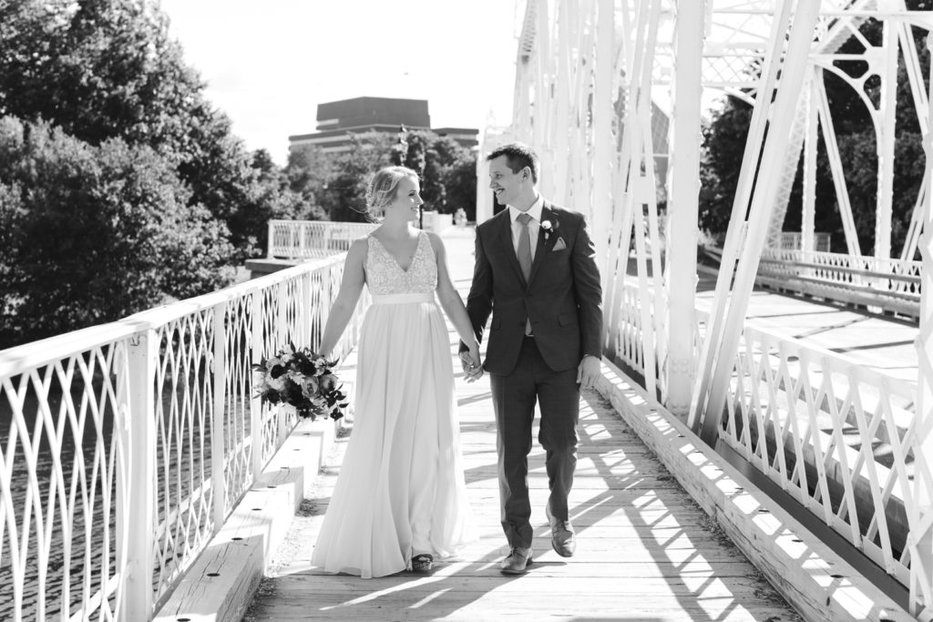 bride and groom walking down Union Street Bridge in Ottawa holding hands