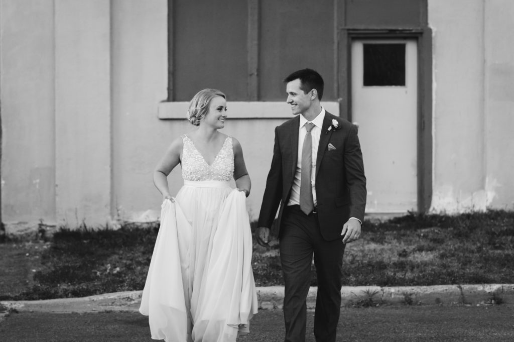 bride and groom walking together smiling at each other