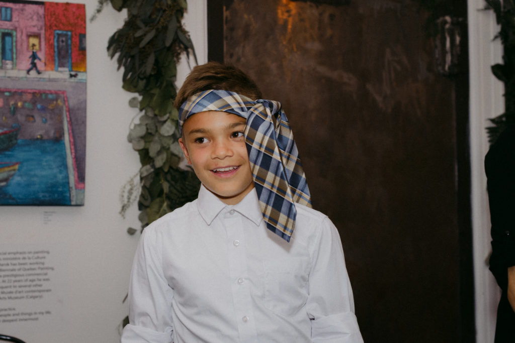 little boy with tie around his head at wedding