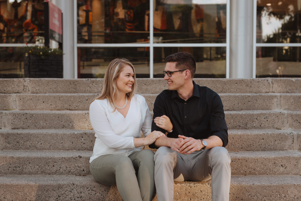 engaged couple sitting on steps of Carleton University campus