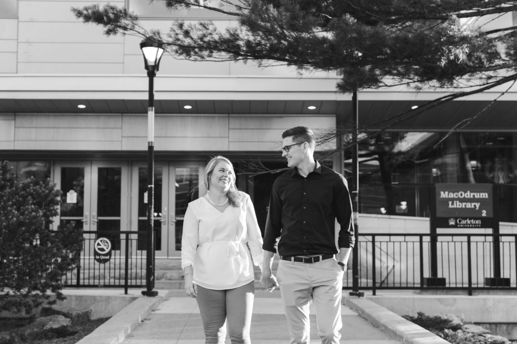 engaged couple holding hands walking around campus