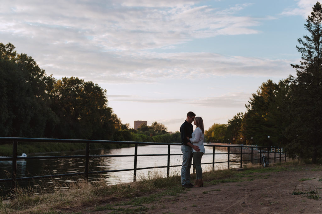 engaged couple standing by the canal in Ottawa at sunset