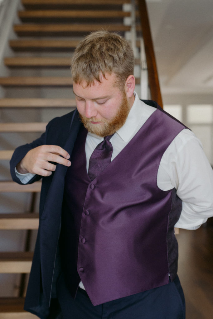 groom putting on his suit jacket