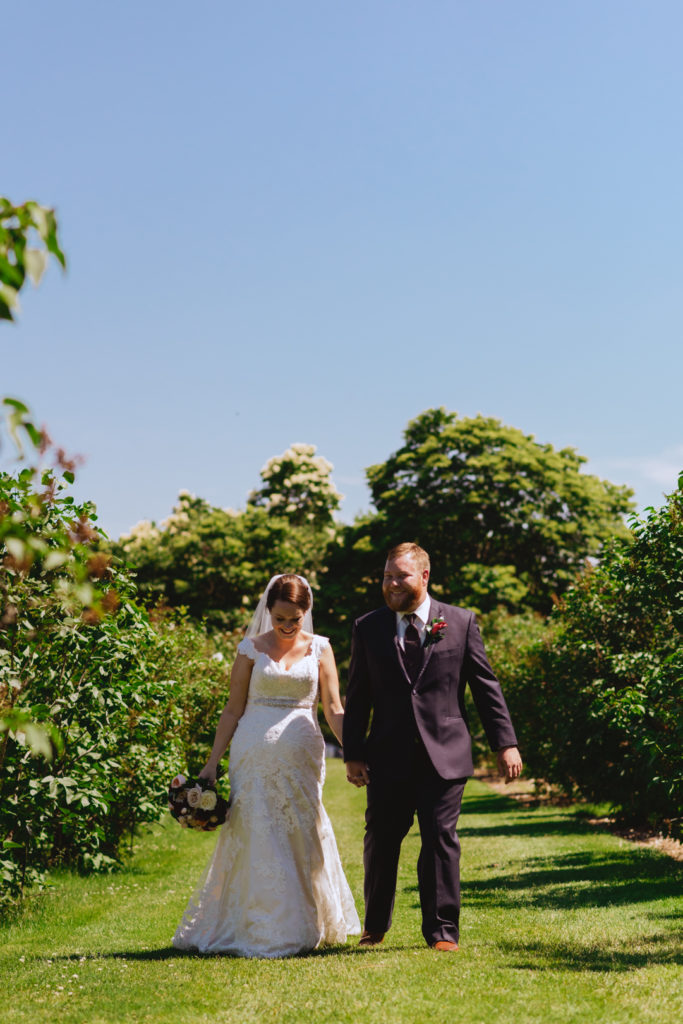 bride and groom walking through tree lined path in the Ornamental Gardens