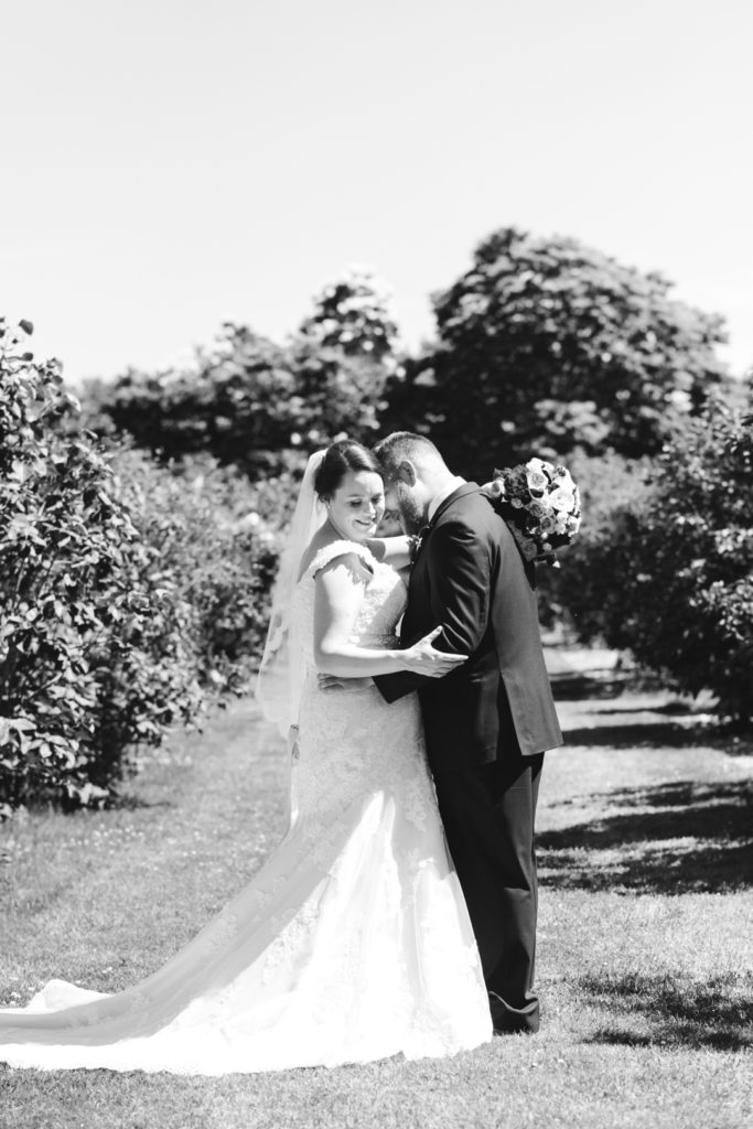 portrait of bride and groom cuddling in the Ornamental Garden in black and white