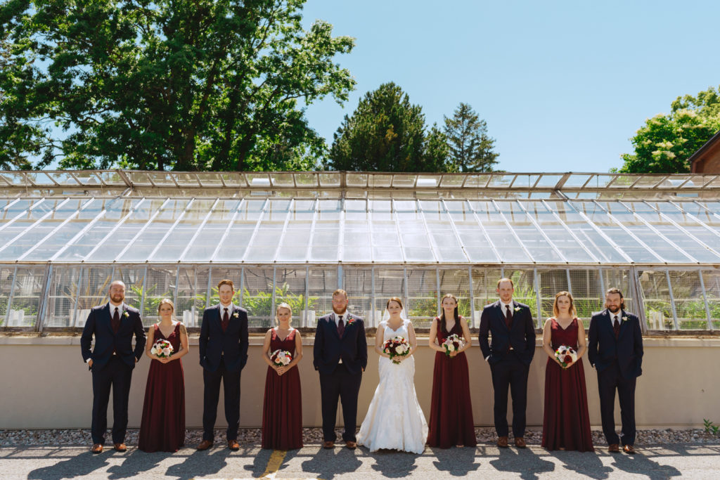 wedding party standing in front of greenhouse at the Experimental Farm