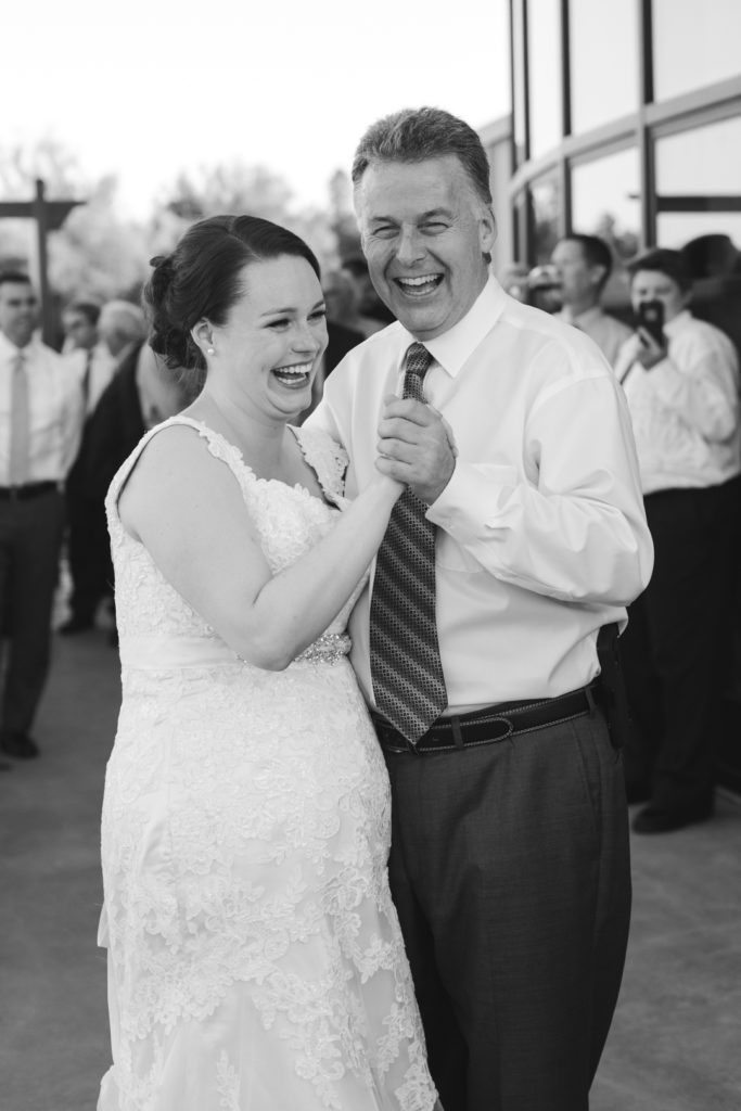 father of the bride and his daughter laughing while dancing