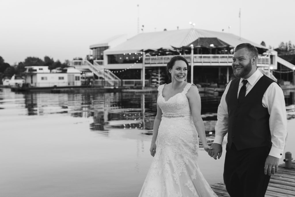 bride and groom walking on the docks of dows lake outside of lago bar grill