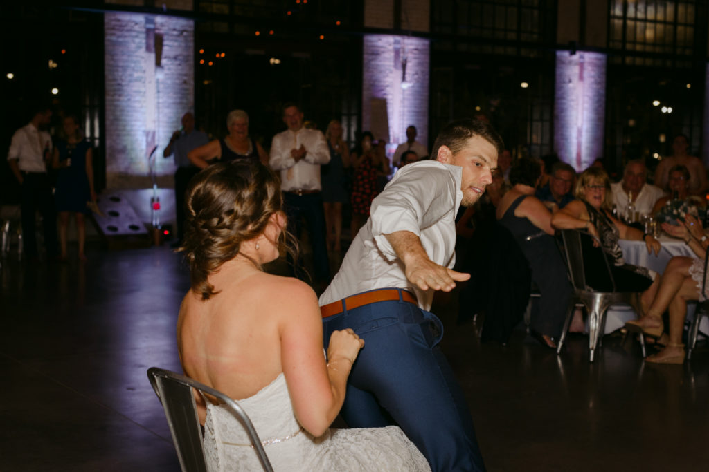 groom smacking his butt in front of bride during garter toss