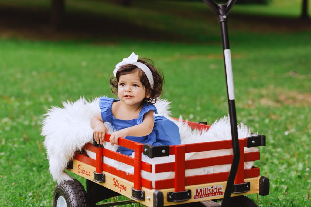 flower girl sitting in a red wagon