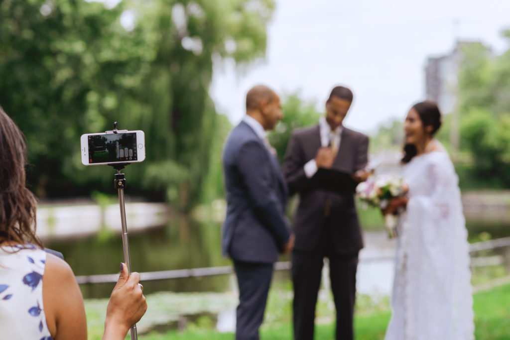 guest holding up telephone for Facebook live during wedding ceremony