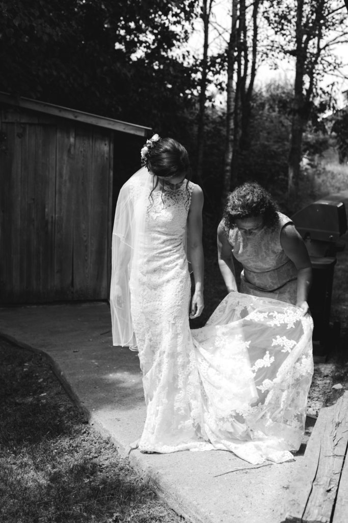 bride's mother helping her daughter into her wedding dress