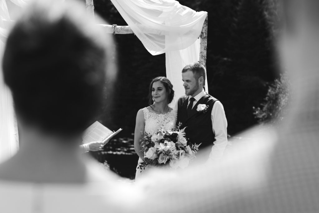 bride and groom standing under birch tree altar