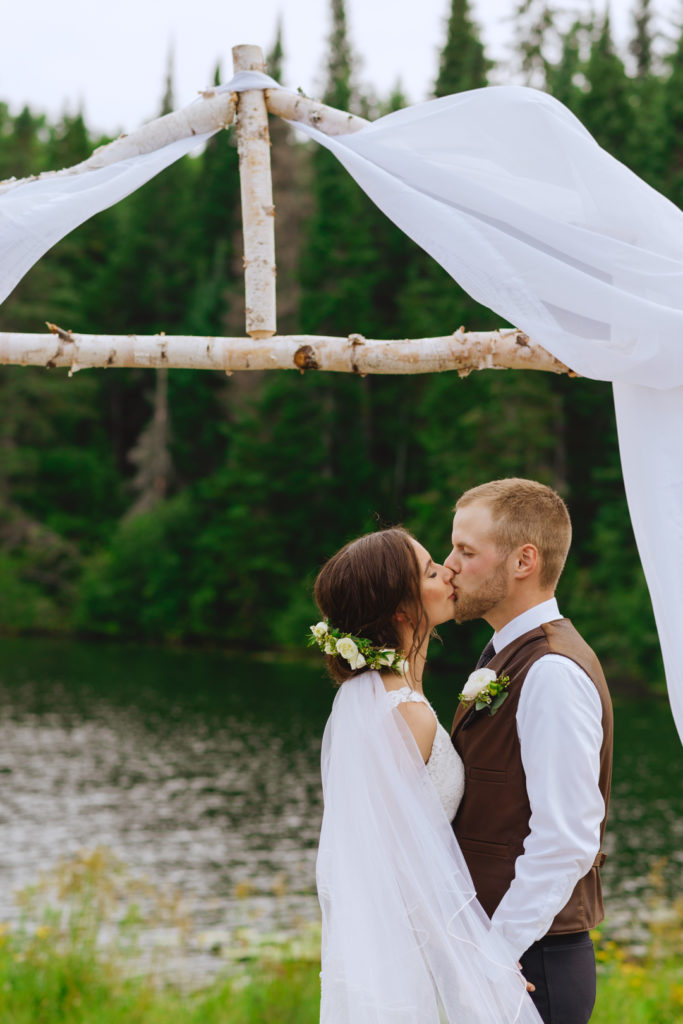 bride and groom first kiss under birch tree altar
