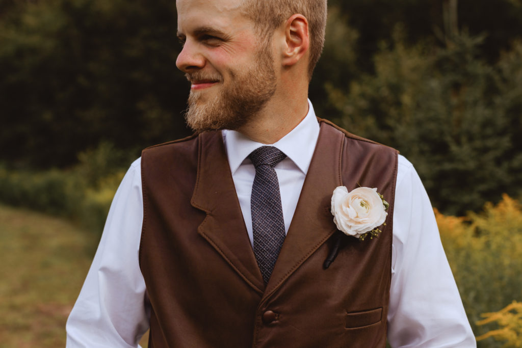 groom wearing a brown leather vest