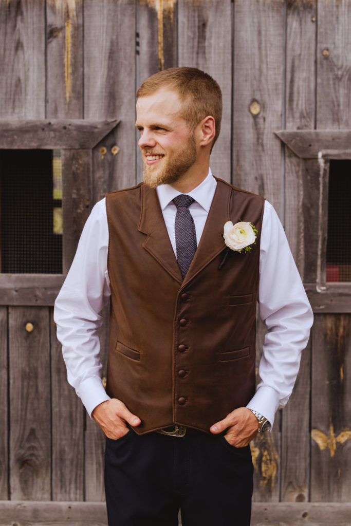 groom wearing a brown leather vest