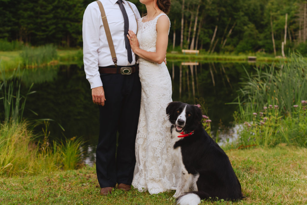 dog smiling at the camera next to bride and groom