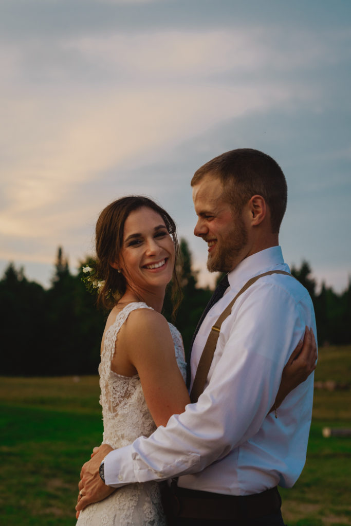 bride and groom laughing at sunset