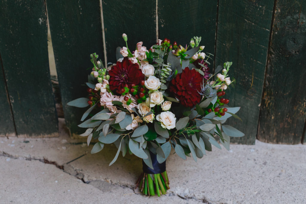 bride's bouquet in red and green against old green barn board