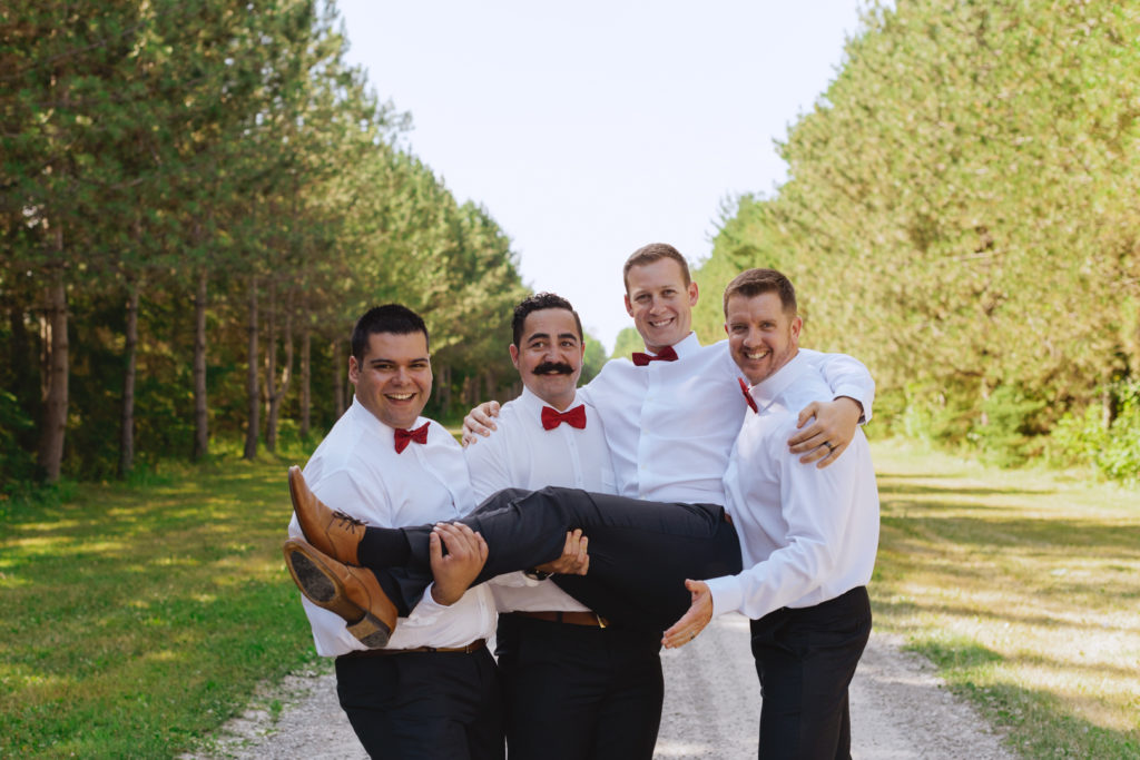 groomsmen holding the groom up
