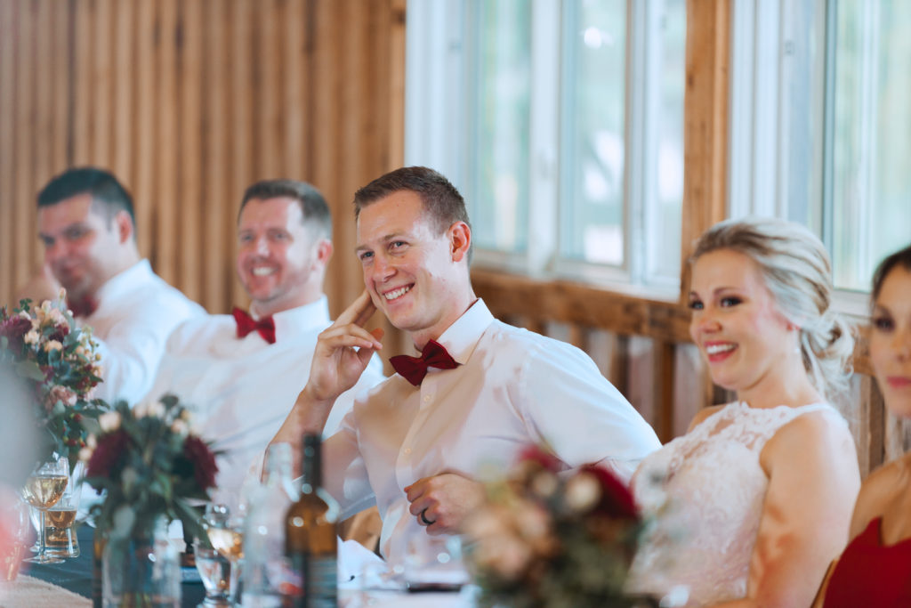 groom laughing at the best man's speech