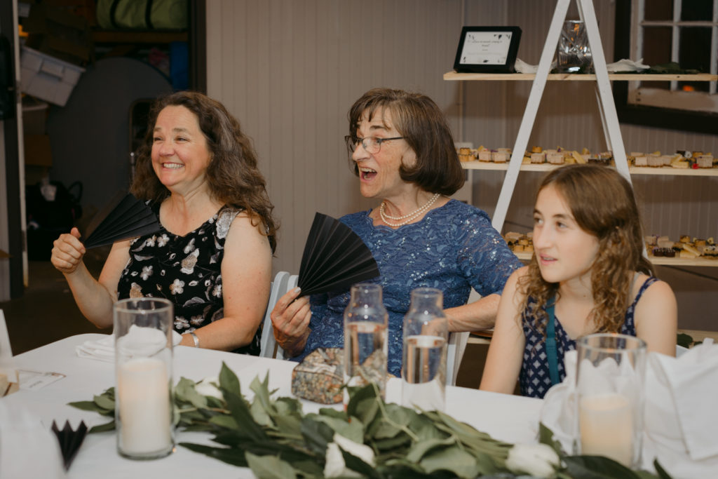 groom's family laughing at wedding speeches