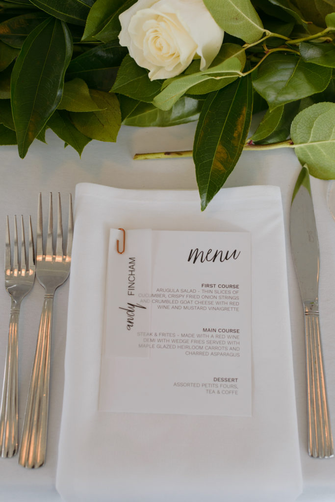 table setting with menu and white and green florals