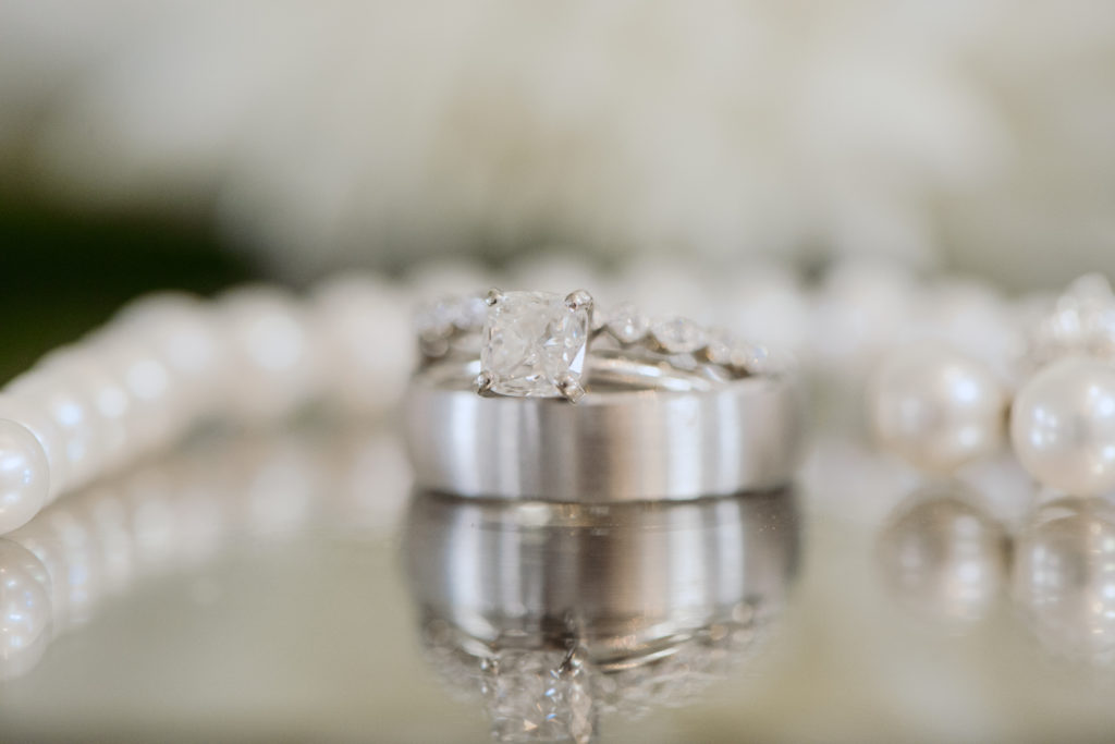wedding rings and pearls on glass table