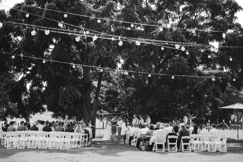 black and white photo of wedding reception underneath a tree