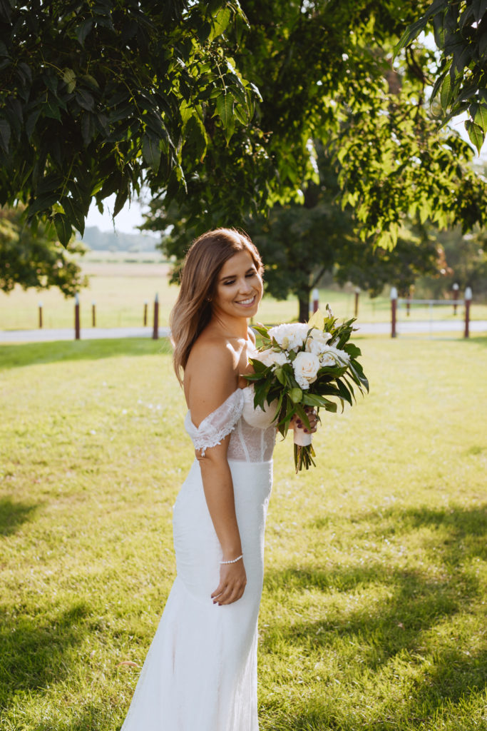 bride standing underneath a tree in a field