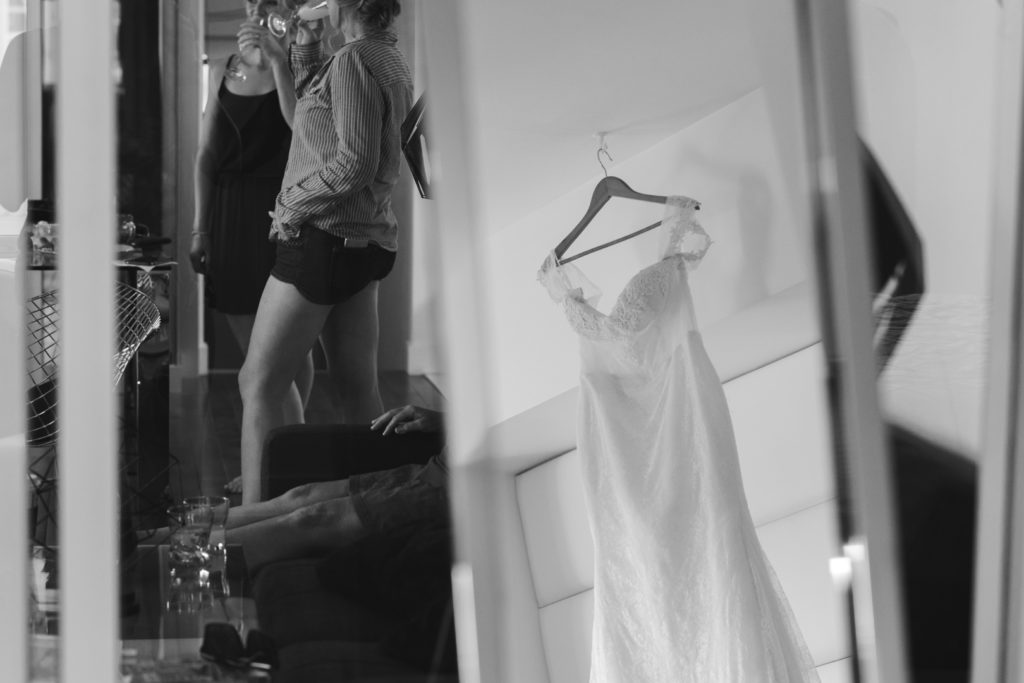reflection of bride's dress in a mirror while bridesmaids get ready