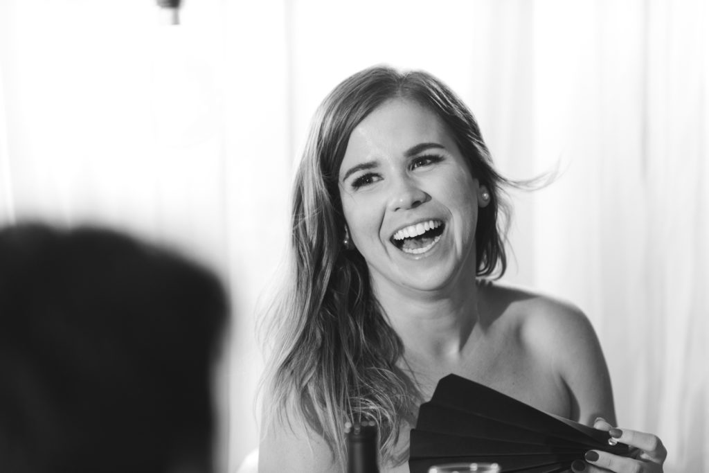 bride laughing at speech during wedding reception