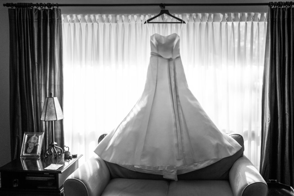 wedding dress hanging in front of window