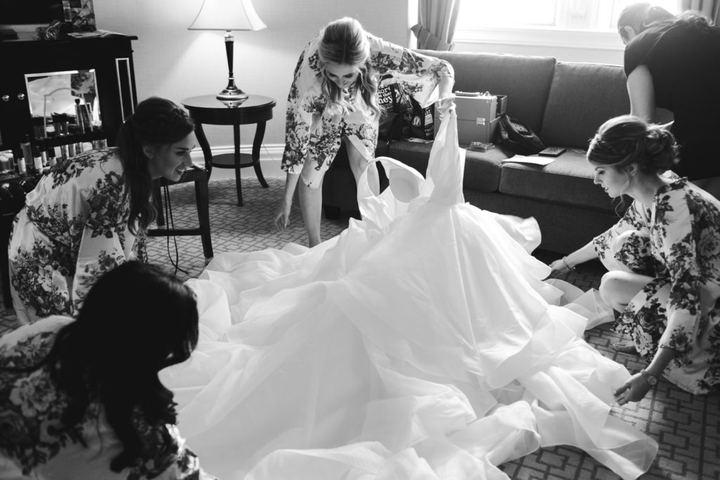 bridesmaids laying out the bride's dress to step into