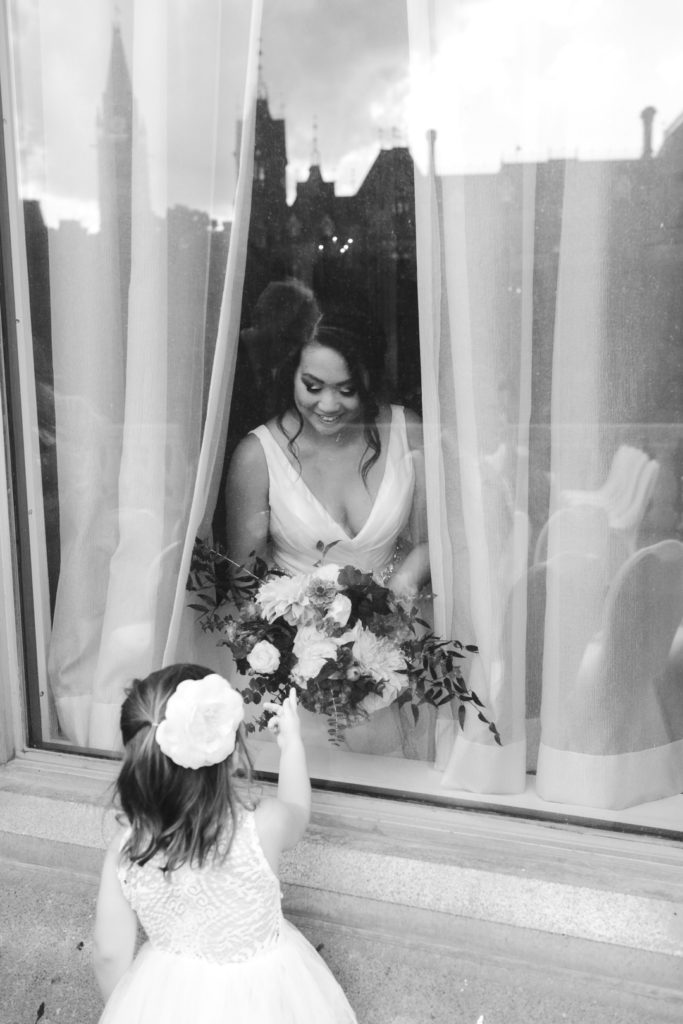flower girl seeing the bride from the window before ceremony