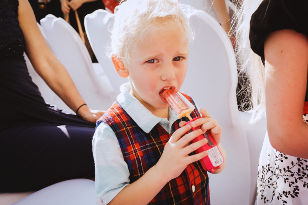 kid having popsicle during outdoor wedding ceremony