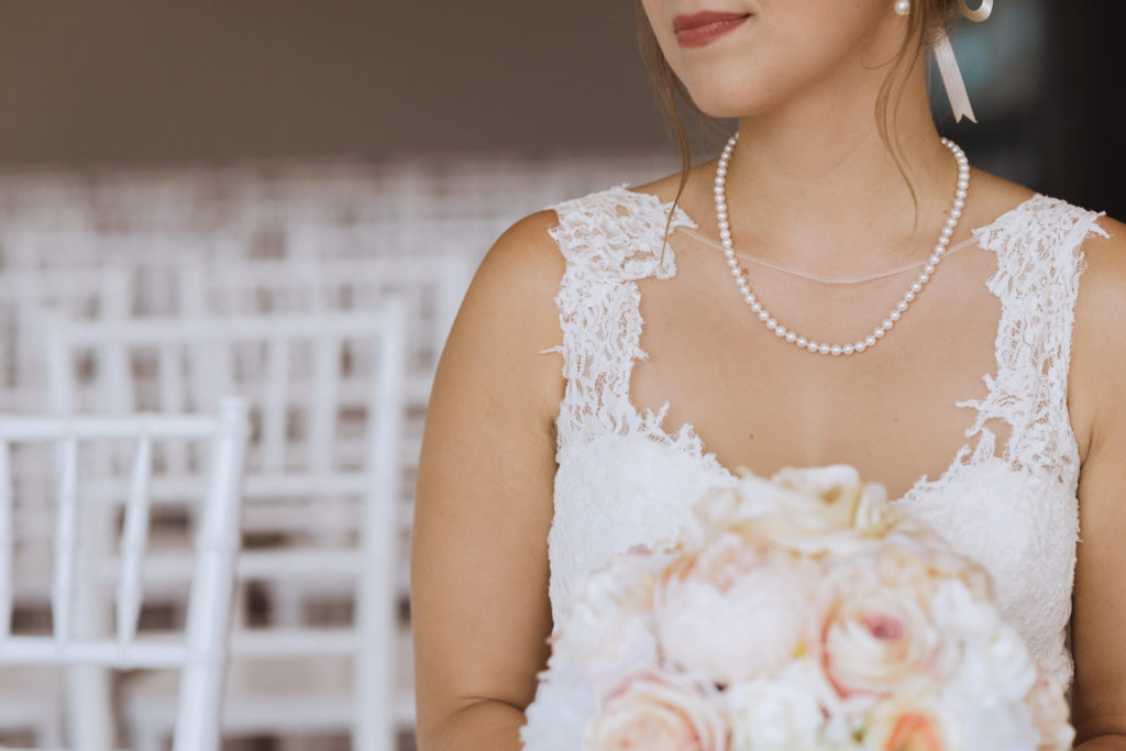 bride wearing lace dress with pear necklace