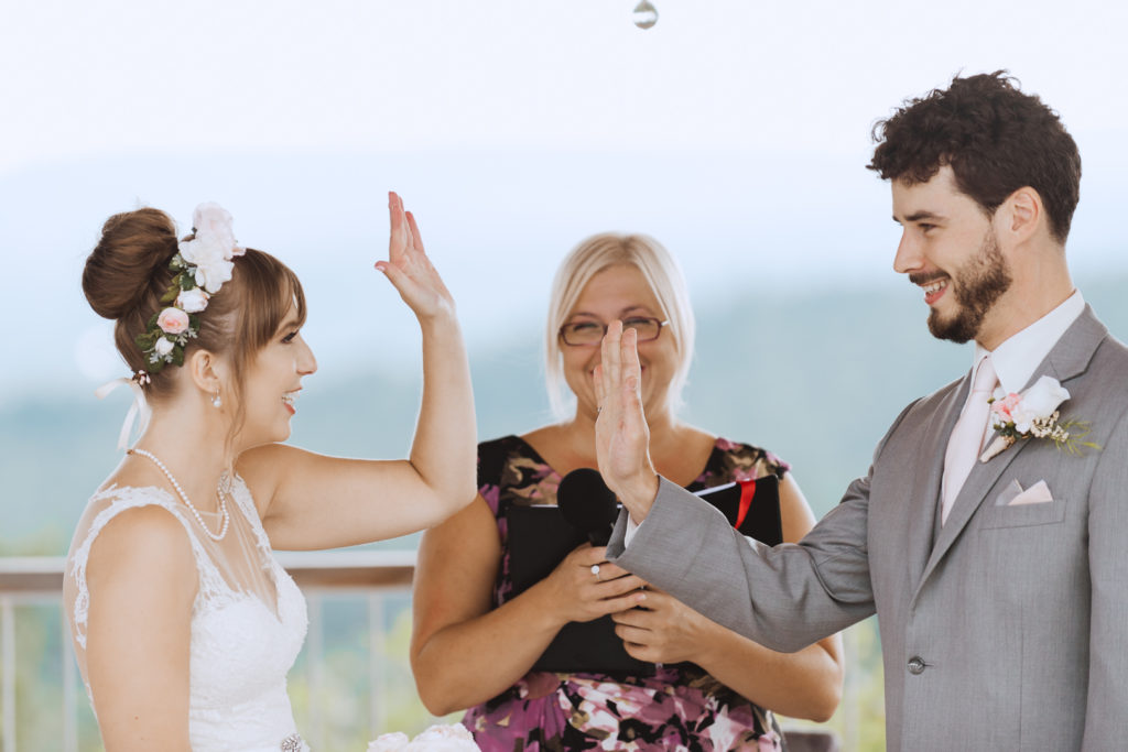 bride and groom high five during wedding ceremony