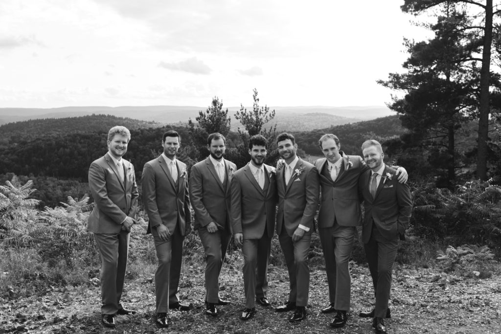 groom and groomsmen on cliffside at Le Belvedere