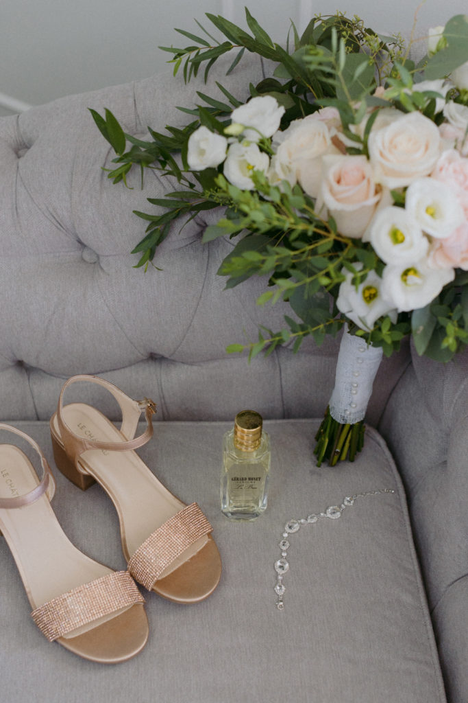 bride's shoes and perfume with flowers