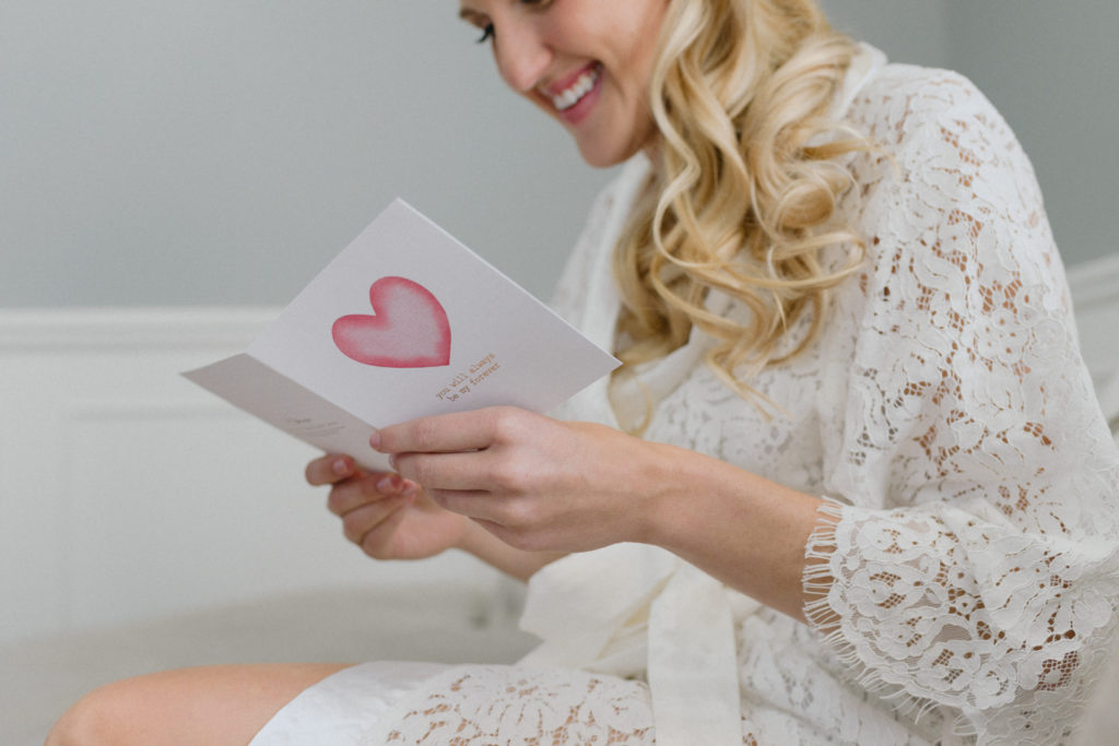 bride reading a card from her groom on the wedding day
